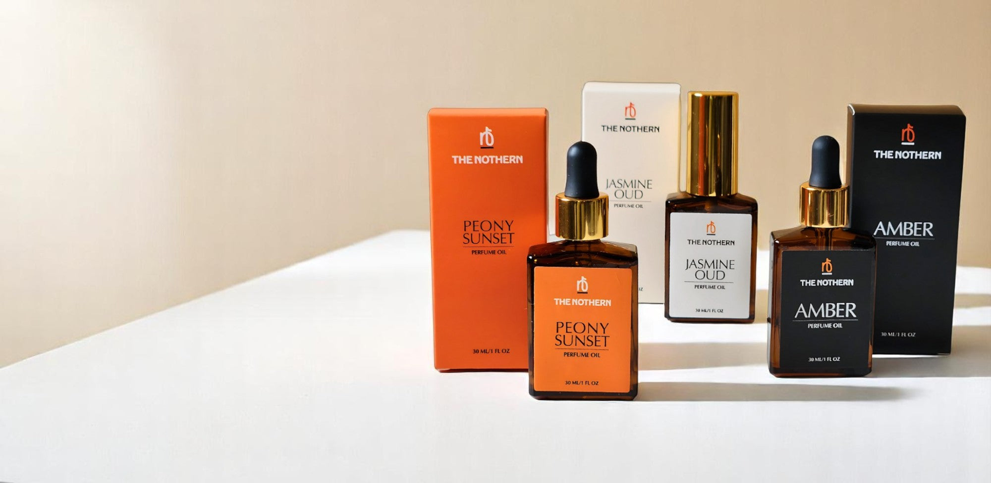 Three Perfume Oil Bottles and boxes on beige & white background | The Nothern